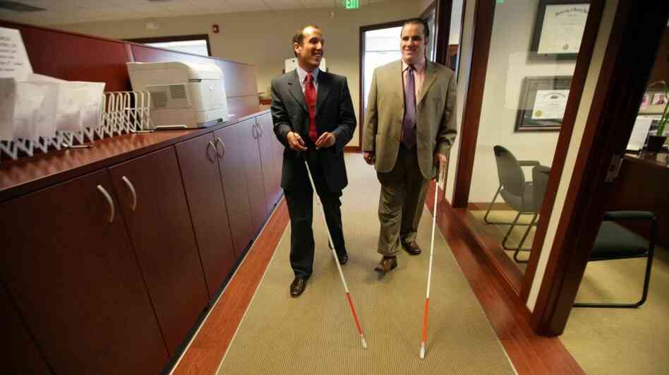Attorney Richard Bernstein (left) and Angelo Binno walk through the law office of The Bernstein Law Firm in Farmington Hills, Mich., on May 24. Binno, who is legally blind, is suing the American Bar Association, saying its standards don't accommodate blind law school applicants. Attorney Richard Bernstein (left) and Angelo Binno walk through the law office of The Bernstein Law Firm in Farmington Hills, Mich., on May 24. Binno, who is legally blind, is suing the American Bar Association, saying its standards don't accommodate blind law school applicants.